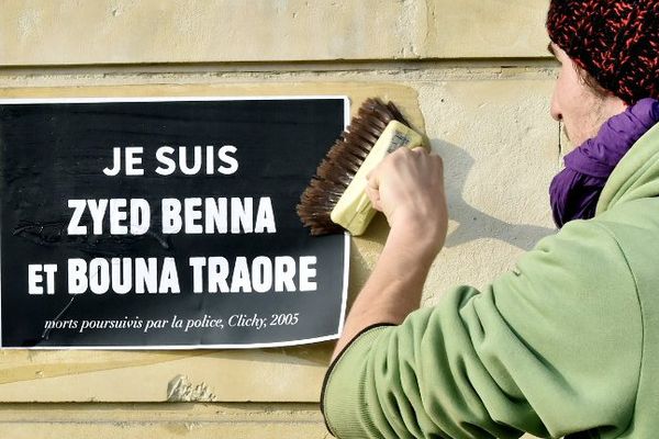 Un homme colle une affiche de soutien aux familles de Zyed et Bouna, en marge du procès qui s'est tenu à Rennes du 16 au 20 mars 2015.