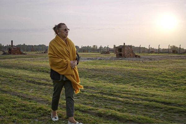 Maria Daumas foulant le sol de l'ancien camp de concentration et centre d'extermination d'Auschwitz, où une partie de sa famille a été exterminée.