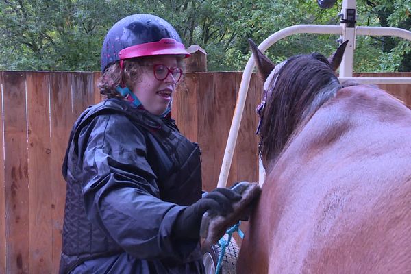 À 28 ans, Pauline rayonne au contact des chevaux : "C'est bien ma poupée", murmure-t-elle à l'animal qu'elle brosse avec délicatesse avant la promenade. L'instant est paisible, la jeune femme affiche un grand sourire.