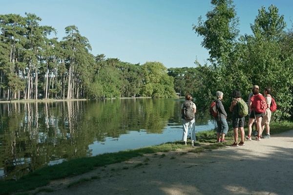 Un groupe s'arrête au bord du lac du bois de Boulogne pour admirer la vue