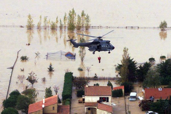 Un hélicoptère des secours évacue des habitants de Cuxac-d'Aude le 14 novembre 1999