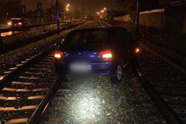 Une voiture sur les rails en pleine nuit. Danger !