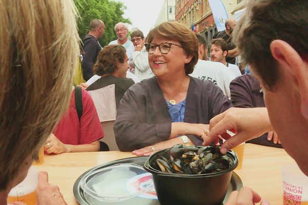 La maire Martine Aubry attablée lors de la braderie de Lille 2022.