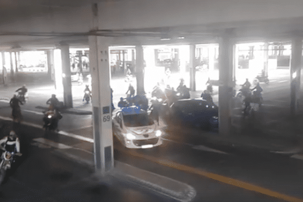 Les scooters escortent la voiture de police dans le parking du centre commercial Grand Littoral à Marseille.