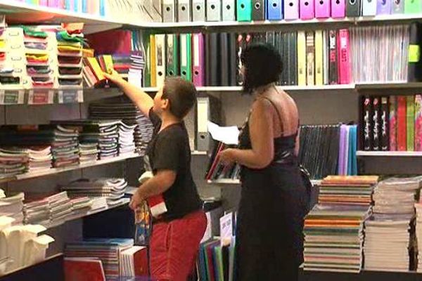 Un enfant et sa maman choisissant des fournitures scolaires