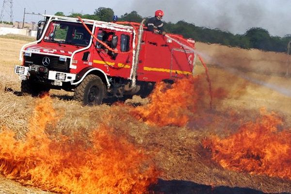 Des pompiers luttent contre un feu de chaume. Photo d'illustration