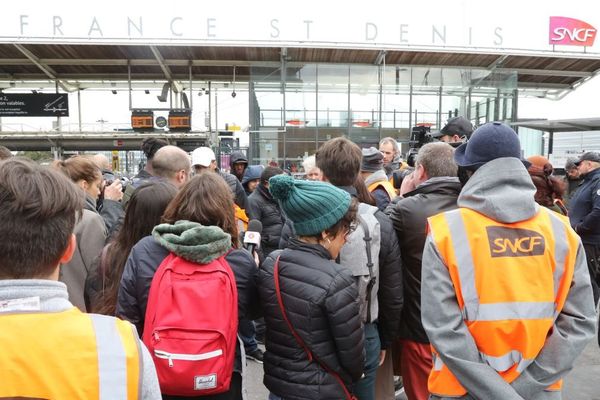 Des cheminots rassemblés devant le siège de la SNCF à Saint-Denis, mardi.