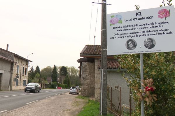 Sandrine Reverdy, une infirmière libérale de 54 ans, a été tuée le 2 août 2021, sur la RD 36, à Jujurieux dans l'Ain. Sa voiture a été percutée par un chauffard qui a pris la fuite. A l'entrée du hameau, près des lieux du drame, son mari a fait poser un panneau qui rappelle le drame.