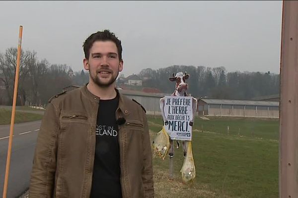 Florian Studer devant le panneau qu'il a planté en bord de route pour éviter les déchets dans ses champs