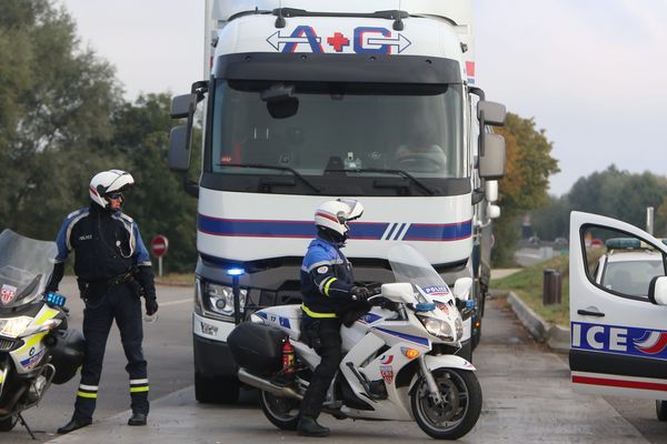 Des CRS intervenant auprès d'un camion à côté d'une autoroute. (image d'illustration)