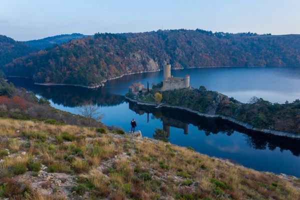 Laurent devant le château médiéval dressé au milieu du lac de Grangent, à Saint-Victor-sur-Loire.