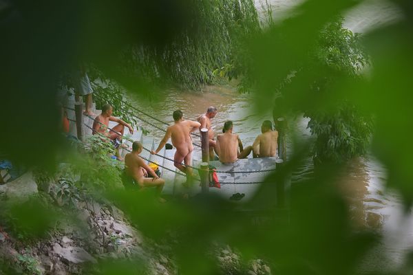 Des nageurs nus sur une plage, à Chongqing, en Chine.