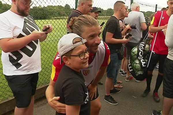 Le néo-Lensois Yannick Cahuzac prend la pose avec un jeune supporter après l'entraînement.