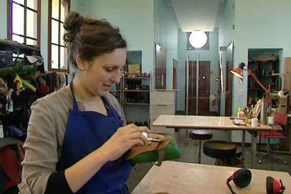 Clémence Nerbusson dans son atelier. Dans ses mains, l'une des chaussures qu'elle portera le 8 mars à l'Elysée.