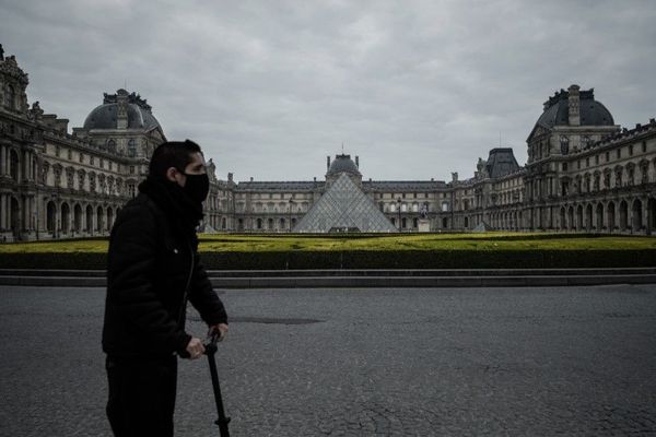 Un homme équipé d’un masque au guidon d’une trottinette, mercredi 18 mars à deux pas du Louvre (illustration).