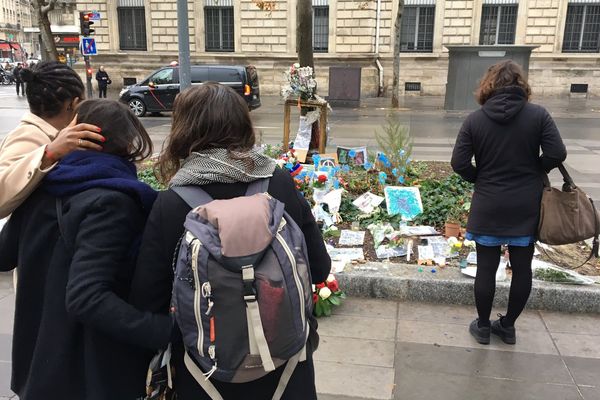 Des passants se recueillent devant l'arbre du souvenir, place de la République, à Paris, le 13 novembre 2016.