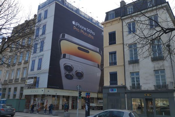 Un affichage publicitaire couvre les travaux du bâtiment à l'angle de la rue Victor Hugo et de la place Bellecour.