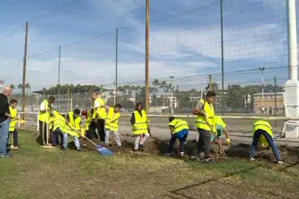 Les jeunes passent leurs vacances à nettoyer leur stade, endommagé par les inondations.