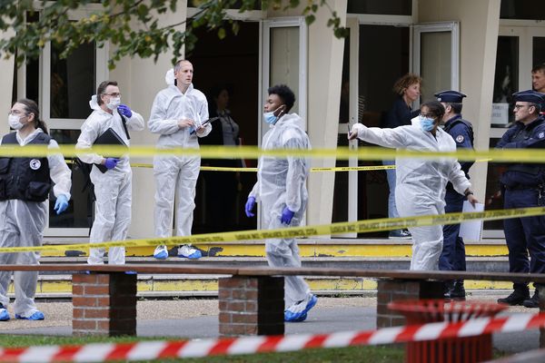 Des policiers français de la police scientifique se tiennent devant le lycée Gambetta à Arras, après l'assassinat d'un professeur dans l'établissement vendredi 13 octobre.