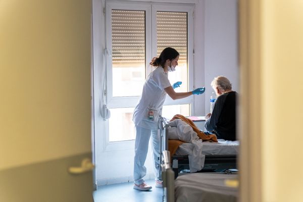 Une jeune infirmière prodigue un soin à une personne âgée à l'hôpital Saint Camille de Bry sur Marne.