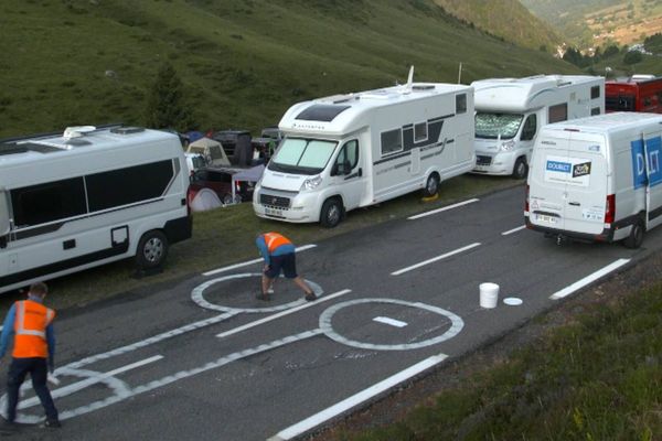 Ces employés de la société nordiste Doublet masquent, avant le passage des coureurs, les pénis peints sur le parcours du Tour de France.