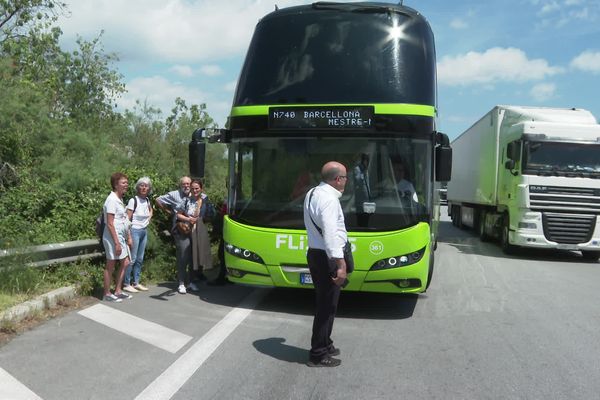 Les passagers de l'autocar bloqués sur l'A9 sont sur la chaussée de l'autoroute alors que la circulation a été rétablie.