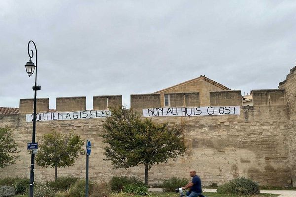 Des banderoles installées sur les remparts d'Avignon, dans la nuit, face au tribunal, pour dénoncer le huit clos lors du visionnage des vidéos du procès des viols de Mazan.