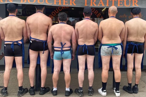 L'équipe de la boucherie prend la pose devant la vitrine du magasin.