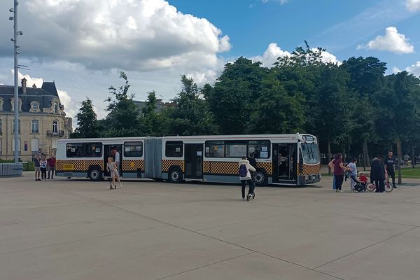 Des badauds viennent à la découverte du bus à damiers jaunes et noirs.