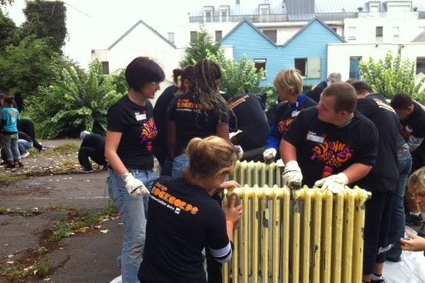 Des bénévoles sont en train de nettoyant les radiateurs de l'association Team, dans le cadre de l'Orange Rock Corps. 