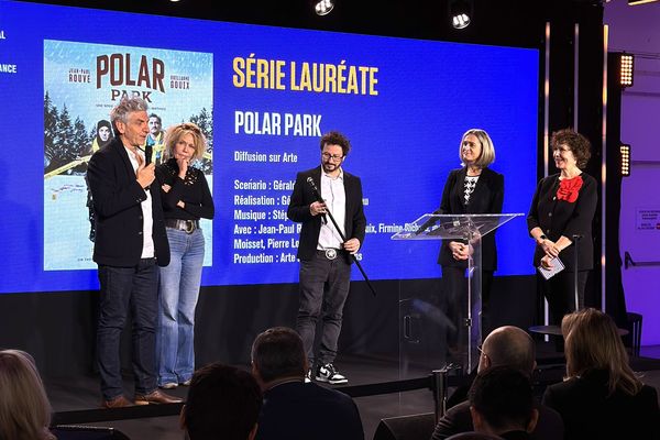 Gérald Hustache-Mathieu (au centre, canne en main), contemple la "canne de Vidocq", symbole marquant la victoire du Prix Vidocq, qui récompense la meilleure série policière de l'année, pour Polar Park.