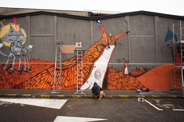 100Taur devant une partie de la gigantesque fresque