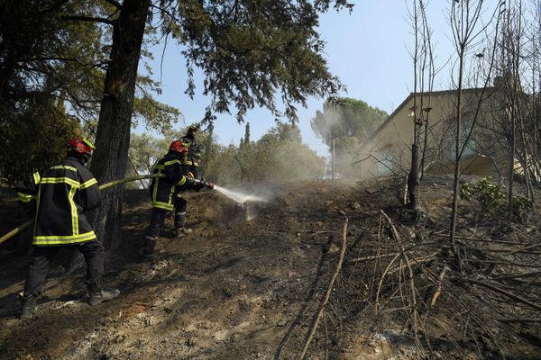 Des sapeurs-pompiers du Var éteignent des flammes près d'une maison lors d'un incendie, le 17 août 2021.