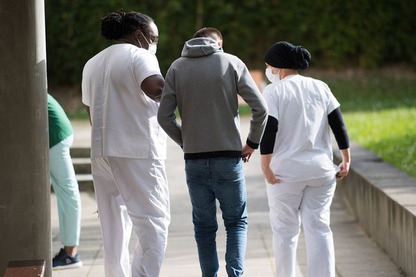 - Photo d'illustration - Un patient se promène avec des membres du personnel médical