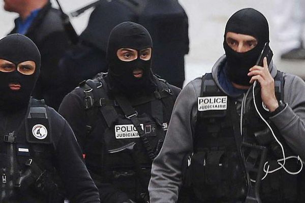 Des policiers cagoulés marchent dans une rue de Saint-Denis, le mercredi 18 novembre 2015. 