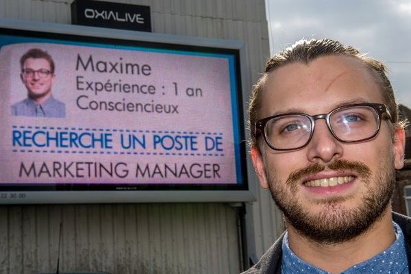 Un demandeur d'emploi pose devant son CV. 