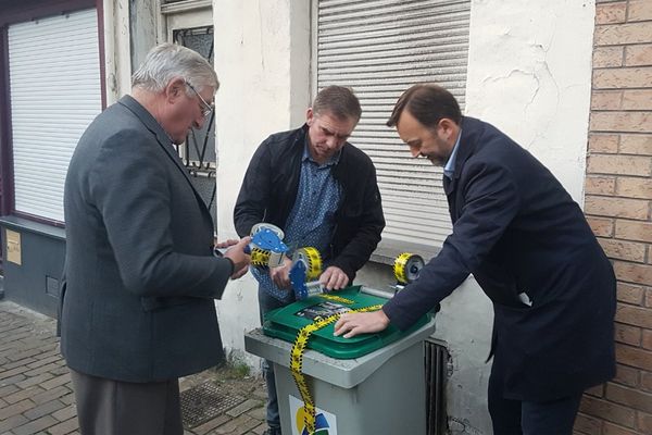 Le maire François Decoster (à droite) scotche une poubelle laissée devant une maison de Saint-Omer