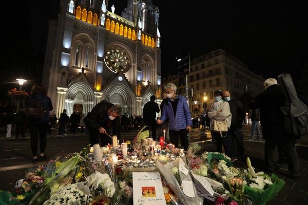 Des passants allument des bougies devant la basilique Notre-Dame, à Nice, le soir de l'attentat.