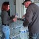 L'employée de mairie est en charge de la distribution d'eau en bouteille pour les habitants