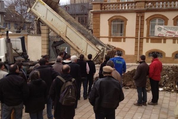 De la terre et des gravats devant la préfecture pour reconstituer une zone humide