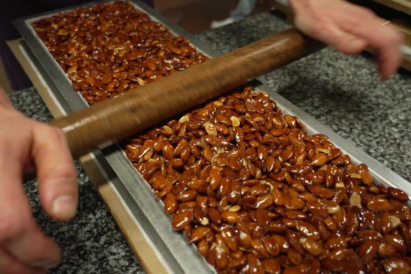 Une fois mélangées avec le miel et le sucre, les amandes sont positionnées sur une grande plaque en métal, pour donner au nougat sa forme de barre.