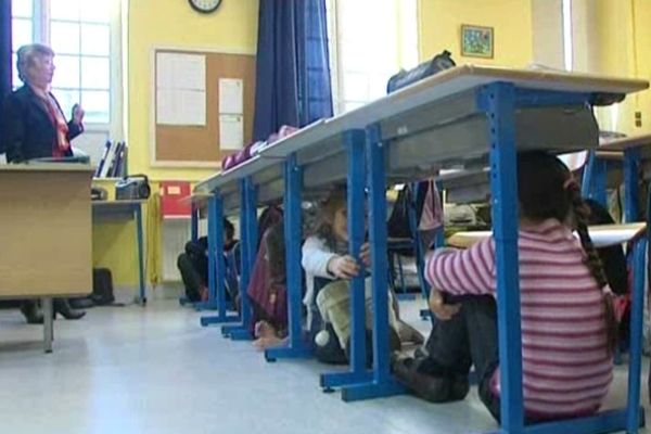 Des enfants de l'école Paul Bert à Tarbes s'abritent sous les tables lors d'un exercice de simulation d'un séisme.