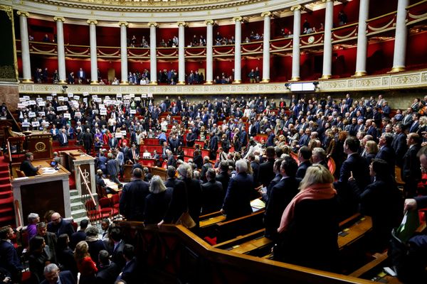 Des députés de la coalition de gauche NUPES tiennent des pancartes sur "Liberté", "Egalite", "Fraternité", après le vote du projet de loi visant à contrôler l'immigration, à l'Assemblée nationale, le 19 décembre 2023