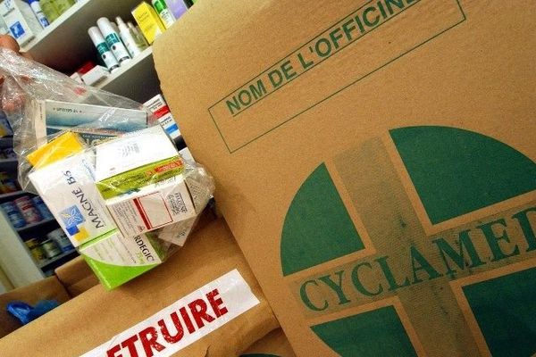 Un pharmacien remplit un carton réservé à la récupération des médicaments usagés ou périmés rapportés par les clients, dans le cadre de l'opération Cyclamed (archives)
