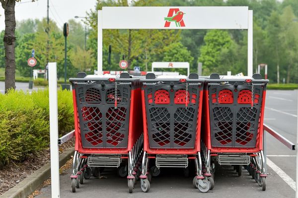 Des caddies devant un magasin Auchan