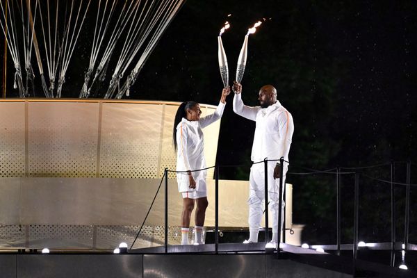 Marie-José Pérec et Teddy Riner allumant la flamme des Jeux de Paris 2024.