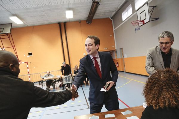 Patrice Bessac, candidat Front de gauche, qui salue des personnes en charge de son bureau de vote à Montreuil