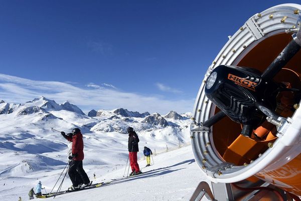 Des skieurs et un canon à neige sur le domaine skiable de Bellevarde à Val d'Isère.