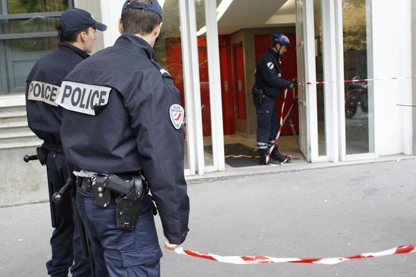 Des policiers établissent un périmètre afin de mener leur enquête après l'accident qui a fait trois blessés graves, une femme et ses deux enfants, à la suite d'une chute de six étages, d'une cabine d'ascenseur dans un immeuble du XIe arrondissement de Paris (2011)