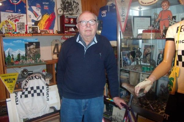 Claude devant ses vitrines : une passion sans frein pour le cyclisme!